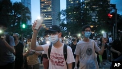 Para demonstran pro-demokrasi menyalakan senter dari gawai mereka dalam aksi protes menandai ulang tahun pertama dari demonstrasi massa menentang RUU ekstradisi yang sekarang ditarik di Hong Kong, Selasa, 9 Juni 2020. 