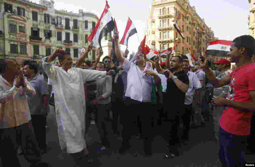 Supporters of the Muslim Brotherhood's presidential candidate Mohamed Morsi carry a poster for him as they celebrate his victory in the presidential elections in Cairo, June 24, 2012. (Reuters)