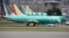 FILE - Boeing 737 Max aircraft, including a 737 Max 8 aircraft bearing the logo of China Southern Airlines (3rd left), are parked at a Boeing production facility in Renton, Washington, March 11, 2019.