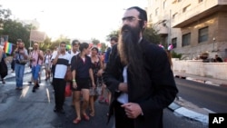 Ultra-Orthodox Jew Yishai Schlissel walks through a Gay Pride parade and is just about to pull a knife from under his coat and start stabbing people in Jerusalem, July 30, 2015. 