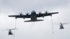 A U.S. Air Force KC130J refueling tanker and two French Caracal helicopters fly over the Champs Elysees during the Bastille Day military parade in Paris, France, July 14, 2016. 