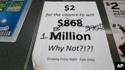 An updated paper sign is displayed the counter of a 7-Eleven store shows that the Mega Millions estimated jackpot has soared to $1 billion Oct. 19, 2018, in Chicago. No one won Friday, and the jackpot is estimated to be $1.6 billion by Tuesday's drawing.