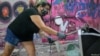 Luciana Holanda destroza el monitor de una computadora en Rage Room, un lugar en Sao Paulo, Brasil, donde la gente puede destruir artículos del diario vivir para desahogar su furia, el 19 de febrero de 2021.