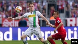 L’attaquant Rafinha de Munich, à droite, et André Hahn de Gladbach se battent pour récupérer un ballon lors du match de football de la Bundesliga entre le Bayern Munich et le Borussia Moenchengladbach au stade Allian, à Munich, Allemagne, 30 avril 2016. epa/ SVEN HOPPE