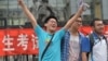A student pose for a photo after taking the 2014 college entrance exam of China, or the "gaokao", outside a high school in Beijing, June 8, 2014.. 