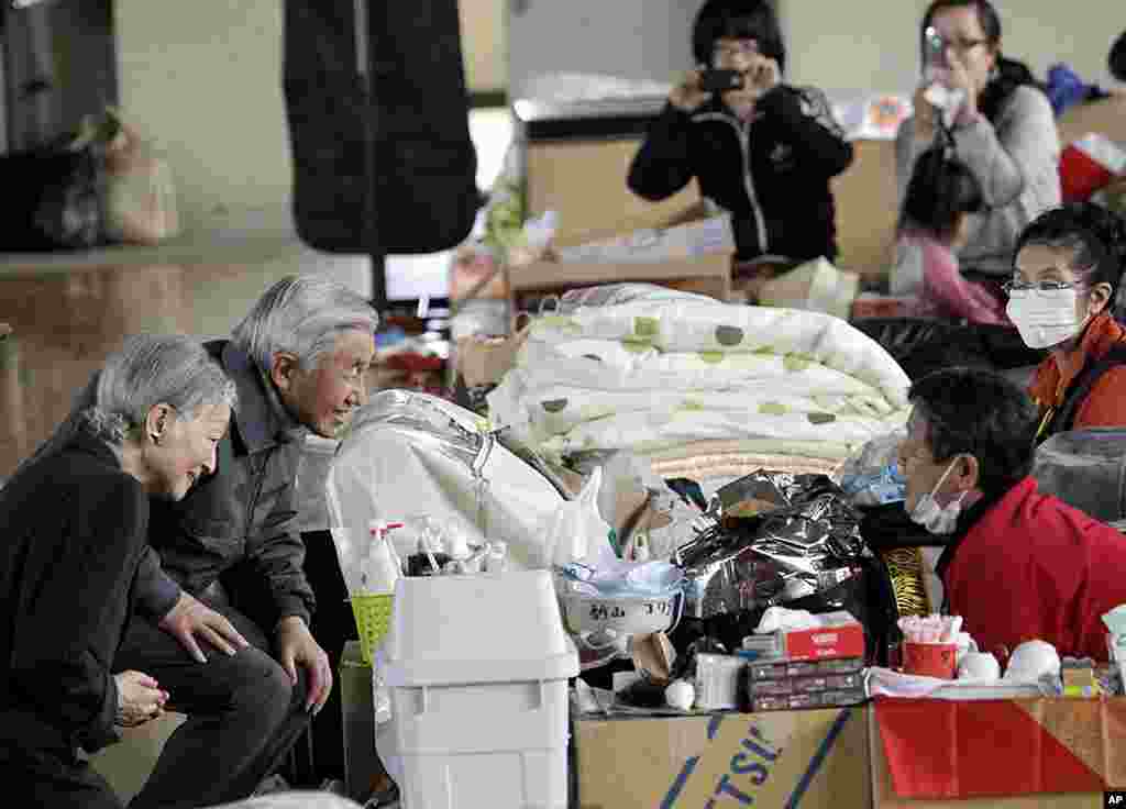 Kaisar Akihito (kedua dari kiri) dan istrinya Michiko, berbicara dengan warga yang dievakuasi di tempat penampungan di Kazo, prefektur Saitama, 8 April 2011. 
