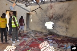 People inspect a damaged mosque following an explosion in Maiduguri, Nigeria, Oct. 23, 2015. Boko Haram is suspected to be behind bombing.