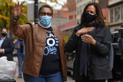FILE - Rep. Marcia Fudge, left, and then-Democratic vice presidential candidate Sen. Kamala Harris wave to employees of Zanzibar Soul Fusion restaurant during a campaign event in Cleveland, Oct. 24, 2020.