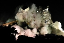 Sisa-sisa bangunan kondominium "Champlain Towers South" di Surfside, Florida saat diledakkan Minggu (4/7).