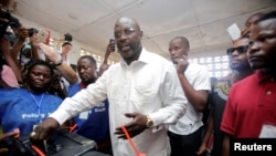George Weah, ancien joueur de football candidat à la présidentielle, dépose son vote à Monrovia, Liberia, le 10 octobre 2017.