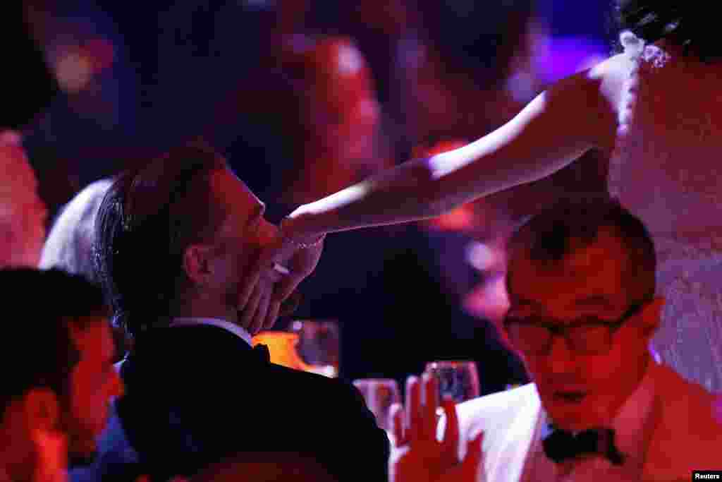 Aktris Prancis Marion Cotillard menyentuh pipi aktor Amerika Leonardo Di Caprio dalam sebuah acara lelang amfAR&#39;s Cinema Against AIDS 2014 di Antibes pada acara Festival Film Cannes ke- 67 di Prancis, 22 Mei 2014.