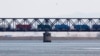 FILE - Trucks drive on the Friendship Bridge over the Yalu River which connects North Korea's Sinuiju to China's Dandong, April 11, 2013.
