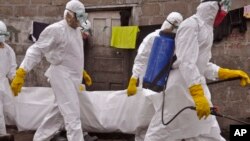 Health workers carry the body of a woman that they suspect died from the Ebola virus, in an area known as Clara Town in Monrovia, Liberia, Sept. 10, 2014. 
