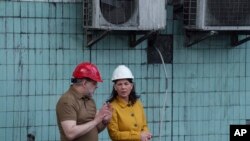 Міністерка закордонних справ Німеччини Анналена Бербок розмовляє з міністром енергетики України Германом Галущенком під час візиту на теплоелектростанцію, зруйновану російською ракетною атакою в Україні, 21 травня 2024 р. (Фото: AP Photo/Євгеній Малолетка)
