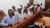 Murder suspects in the killing of Ugandan Police Commander Andrew Felix Kaweesi stand behind the dock at the Nakawa Chief Magistrates court in Kampala, Uganda, May 18, 2017. (H. Athumani/VOA)