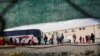 MIgrantes de Centroamérica se hacen fila para las pruebas de COVID-19 en un asilo temporal en Ciudad Juárez, México, y así continuar al pedido de entrada en EE. UU. el 26 de febrero de 2021.
