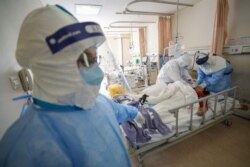 Medical workers in protective suits attend to a patient inside an isolated ward of Wuhan Red Cross Hospital in Wuhan, the epicenter of the novel coronavirus outbreak, in Hubei province, China, Feb. 16, 2020.