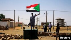 Symbole de la résistance de la contestation, un manifestant, drapeau national en main, défie les forces de l'ordre, à Khartoum, le 5 juin 2019.