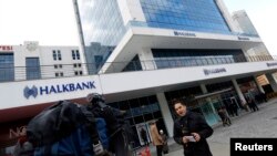 FILE - A TV correspondent reports in front of Halkbank headquarters in Atasehir, in the Asian part of Istanbul.