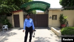 Seorang polisi berjaga-jaga di luar kantor Save the Children di Islamabad, Pakistan, 12 Juni 2015.