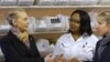 South Africa's Health Minister Aaron Motsoaledi, left, and Secretary of State Hillary Rodham Clinton, speak with Calesa Vinger, and Lizette Monteith about pharmacy procedures in a clinic in Delft South, a suburb of Cape Town, South Africa, Aug. 8, 2012.