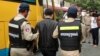 A Chinese national arrested over an alleged internet scam is escorted by police officers to be deported at the immigration office in Phnom Penh, Cambodia, July 26, 2017. 