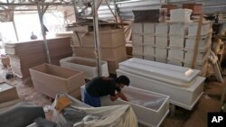 آماده کردن تابوت با رعایت پروتکل‌های کرونا برای جان‌باختگان از این ویروس مرگبار - جاکارتا، اندونزی - ۱۳ ژوئیه ۲۰۲۱