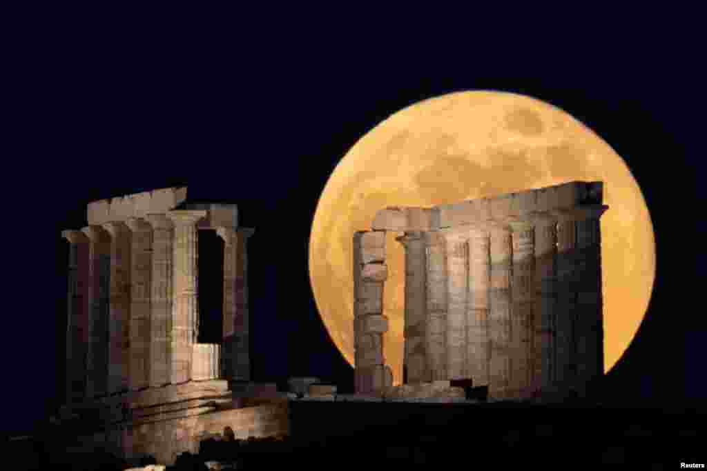 La luna llena, conocida como Superluna, y que este año coincidió con un eclipse lunar, se alza sobre el Templo de Poseidón, cerca de Atenas.
