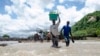 People cross a river with their belongings where a bridge once stood in Phaloni, Southern Malawi, Jan 22, 2015. 