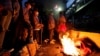 Beberapa demonstran berdiri di dekat barikade yang terbakar selama aksi protes terhadap kenaikan harga BBM di luar kompleks Monumen Nasional di Jakarta, Selasa malam 13 September 2022.