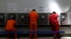 Inmigrantes detenidos en EE.UU., muchos de ellos centroamericanos, usan teléfonos públicos en un centro de detención en California, el 28 de agosto de 2019.