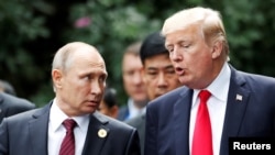 Le président américain Donald Trump, à droite, et son homologue russe Vladimir Poutine lors d'un sommet à Danang, Vietnam, 11 novembre 2017.