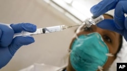 Yomaris Pena, Dokter Penyakit Dalam di Somos Community Care di COVID-19 mengekstrak Vaksin Pfizer COVID-19 dari vial di tempat vaksinasi. (Foto: AP)