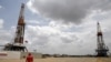 Un trabajador de un campo petrolero camina junto a las plataformas de perforación en un pozo petrolero operado por la petrolera estatal venezolana PDVSA, en la rica franja petrolera del Orinoco, el 16 de abril de 2015.