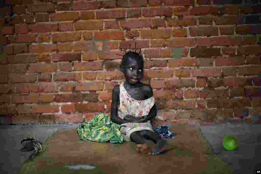 Amandine, 7, who found refuge in the Mbaiki cathedral, in Mbaiki, some 120kms (75 miles) south west of bangui, Central African Republic, sits on the ground, Sunday, Jan. 26, 2014. Amandine, who lost both parents five years ago, cannot speak nor walk. She
