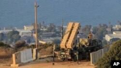 Des soldats israéliens à côté d'une batterie d'intercepteurs de roquettes patriotes déployée dans la ville de Haïfa, Israël, 28 août 2013. 