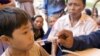 A U.S sailor gives a medical treatment to a Cambodian boy at a Buddhist pagoda, outside of Sihanoukville city, file photo. 