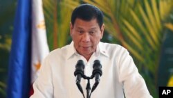 FILE - Philippine President Rodrigo Duterte addresses a crowd during a news conference. Founded in 1968, the rebels' communist party has held peace talks with six Philippine presidents, including Duterte.