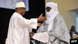 Le président du Mali Ibrahim Boubacar Keita (gauche) embrasse un représentant de la coalition des rebelles touaregs, Mahamadou Djery Maiga, à Bamako, Mali, 20 juin 2015.
