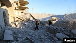 Warga memeriksa kerusakan setelah serangan udara yang dilancarkan oleh pasukan pro pemerintah Suriah di kota Anadan, sekitar 10 km dari kota Nubul dan Zahraa, Aleppo utara, Suriah, 3 Februari 2016.