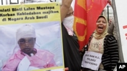 Para pekerja Indonesia meneriakkan slogan saat menggelar aksi protes menentang penyiksaan tenaga kerja Indonesia di Arab Saudi, di luar gedung DPR/MPR RI di Jakarta, 23 November 2010 (Foto: dok). 