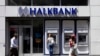 FILE - A customer uses an automated teller machine at a branch of Halkbank in Istanbul, Aug. 15, 2014. 
