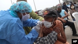 Crisologo Enriquez, 85 tahun, sedans divaksin saat kampanye vaksinasi dan operasi pengujian Covid-19 di lingkungan Villa El Salvador di Lima, Peru, Jumat, 26 Juni 2020. (Foto: AP)