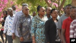 The ruling party CCM presidential candidate Dr. John Magufuli, third left, stands in line to cast his vote at Chamwino in Dodoma, Oct. 28, 2020.