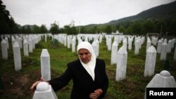 Mejra Dzogaz touches the graves of her two sons on May 17, 2012. Mejra's husband, three sons and a grandson were killed during the Srebrenica massacre in 1995 by a Serbian army unit commanded. 