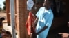 A medical worker weighs a potentially malnutrition child at Mbela health centre in Balaka district, Malawi.