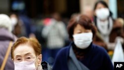 图为日本东京一个购物中心内带着口罩的行人(美联社2020年1月16日资料照)