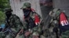 Rebeldes del Ejército de Liberación Nacional (ELN) de Colombia descansan frente a la casa de un agricultor, en las selvas del noroeste de Colombia el 31 de agosto de 2017.