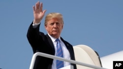 President Donald Trump waves as he boards Air Force One for a trip to West Virginia for a "Salute to Service" dinner, July 3, 2018, at Andrews Air Force Base, Maryland.