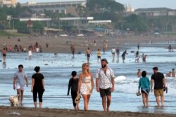 Turis berjalan di pantai saat pemerintah memperpanjang pembatasan untuk mengekang penyebaran COVID-19 di Badung, Bali, 9 September 2021. (Foto Antara/Nyoman Hendra Wibowo/via REUTERS)